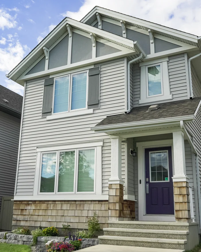 Two story home repainted in light gray with dark shutters and white trim